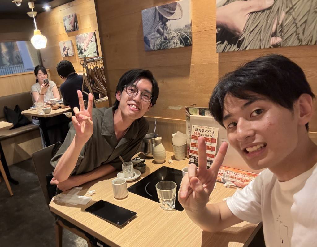 写真：食事中の湯野さんと指揮・後藤さんのツーショット