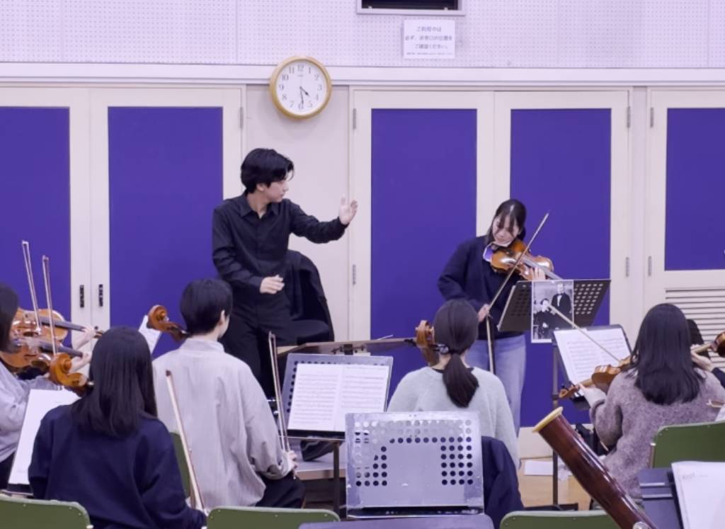 写真：千葉さん（指揮）と久保さん（Vn）の合奏風景